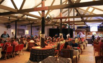 a large group of people gathered in a restaurant , enjoying a meal and socializing together at Fiji Hideaway Resort and Spa