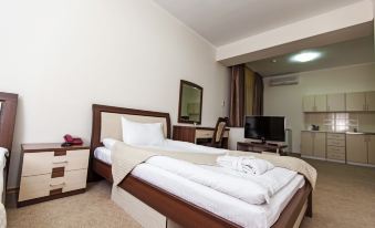 a large bed with white linens is in a room with a wooden headboard and a desk at Alma