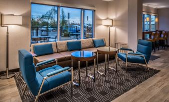 a living room with a couch , chairs , and a coffee table in front of a window at TownePlace Suites Merced