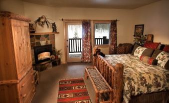 a cozy bedroom with a large bed , a fireplace , and a rug on the floor at Daniels Summit Lodge