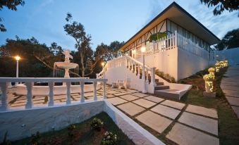 a modern house with a white exterior , surrounded by trees and situated on a hillside at Bilut Hills @ Bentong