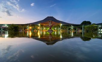 a large , modern building with a central dome and a fountain in front of it at The Sunan Hotel Solo