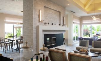 a modern living room with a fireplace , a dining table , chairs , and a television at Hilton Garden Inn Philadelphia/Ft. Washington