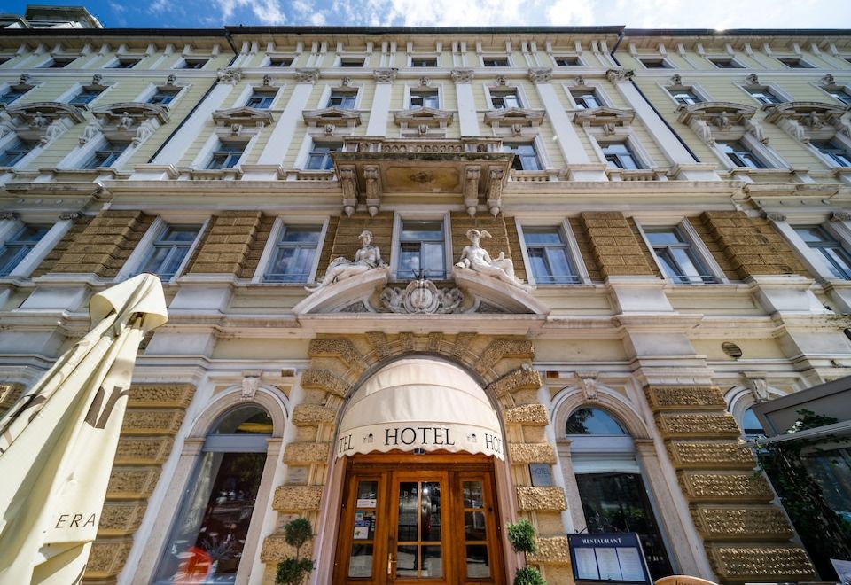 "a large , ornate hotel building with a red door and the name "" hotel "" displayed above the entrance" at Hotel Continental
