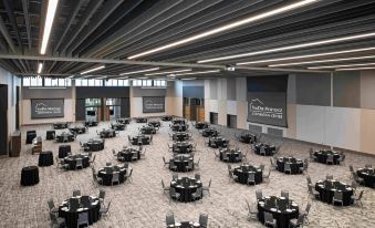 a large banquet hall with multiple round tables and chairs arranged for a formal event at Delta Hotels Muskegon Convention Center