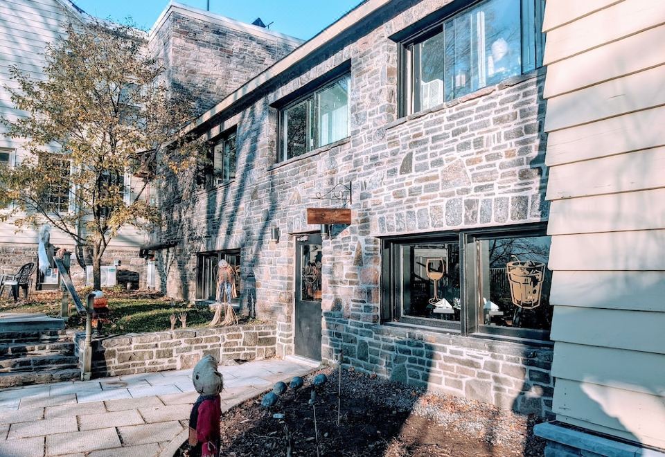 "a brick building with a sign that says "" kate "" is next to a tree and has a red scooter parked in front" at Inn at the Falls