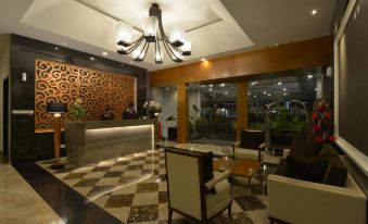 a modern hotel lobby with a checkered floor , a reception desk , and various seating areas at Pranaya Boutique Hotel