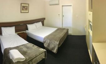 a hotel room with two beds , one on the left and one on the right side of the room at Balonne River Motor Inn