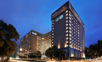 "At night, there is a large building with the word ""hotel"" on its side and another building in front" at Sheraton Grand Taipei Hotel