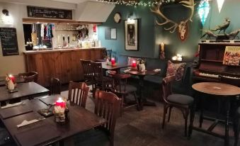 a restaurant with wooden tables and chairs , a bar , and various decorations on the walls at Bulls Head