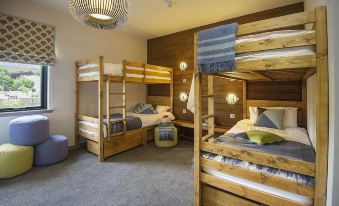 a room with four wooden bunk beds arranged in a row , providing accommodation for multiple people at Lock Chambers, Caledonian Canal Centre