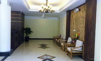a modern hotel lobby with wooden walls , white floor , and comfortable seating arrangements under a hanging light fixture at Saigon-Ba Be Resort