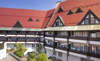 a multi - story building with a red tile roof and balconies is shown from an aerial view at Achat Hotel Kaiserhof Landshut