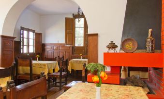 a dining room with wooden furniture , including tables and chairs , and a fireplace in the background at Las Mercedes