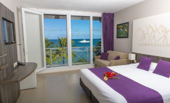 a bedroom with a large window overlooking the ocean , featuring a bed and a couch at Hotel Beaurivage