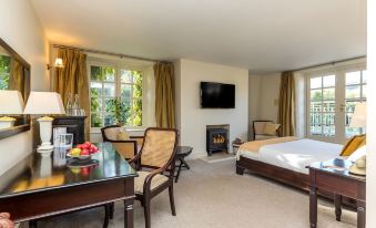a well - appointed hotel room with a comfortable bed , a flat - screen tv , and a dining table at BrookLodge & Macreddin Village