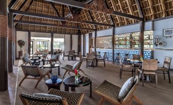 a large room with wooden chairs and tables , a bar , and an ocean view in the background at Shangri-La Yanuca Island, Fiji