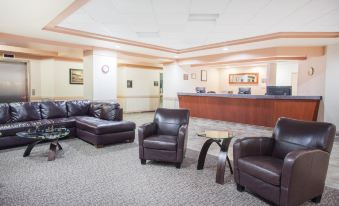 a spacious waiting room with multiple couches , chairs , and a reception desk , creating an inviting atmosphere for guests at Hotel Estevan