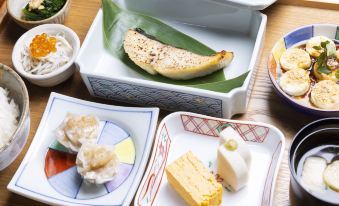 a dining table with a variety of food items , including a banana in a bowl and various desserts at Oakwood Suites Yokohama