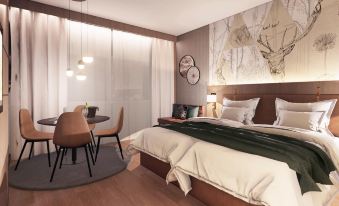 a modern bedroom with a large bed , wooden floors , and a dining area near the window at Mercure HAN Sur Lesse