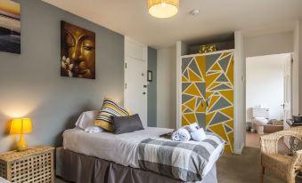 a bedroom with a bed , pillows , and a painting of geometric patterns on the wall at Parsonage Farm Inn