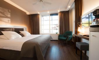 a hotel room with a large bed , wooden floors , and a window overlooking the city at Hotel Emma