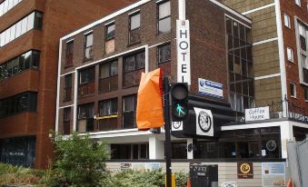 "a modern building with the word "" hotel "" on it , surrounded by other buildings and traffic lights" at Lansdowne Hotel