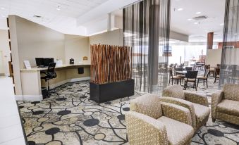 a hotel lobby with various seating options , including couches and chairs , as well as a coffee station at Holiday Inn ST. Petersburg N- Clearwater
