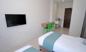 a modern hotel room with two beds , a desk , and a flat screen tv on the wall at Sukro