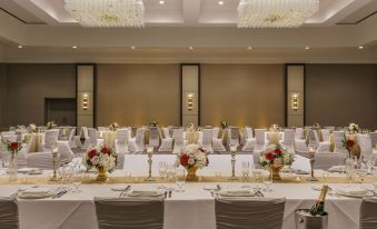 a well - decorated banquet hall with multiple dining tables set for a formal event , featuring white tablecloths , gold centerpieces , and at Grand Hyatt Denver