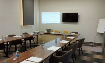 a conference room with a long table , chairs , and water bottles , set up for a meeting at Hotel River