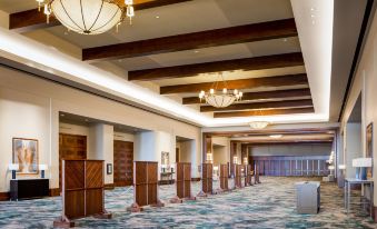 a large , well - lit room with wooden floors and chandeliers , containing multiple carpeted walkways and tall bookshelves at JW Marriott San Antonio Hill Country Resort & Spa