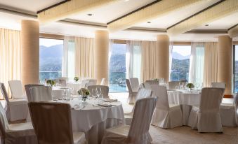 a large dining room with multiple tables and chairs , all set for a formal event at Jumeirah Port Soller Hotel and Spa