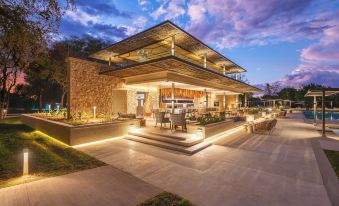 a modern building with a large outdoor patio and seating area , illuminated by lights at night at Mokuti Etosha