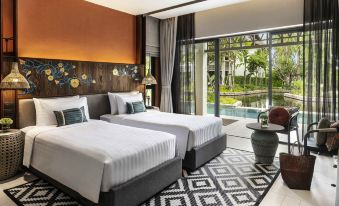 a hotel room with two twin beds , one on the left and one on the right side of the room at Grand Mercure Khao Lak Bangsak