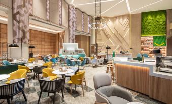 There is a restaurant in the center with tables and chairs, as well as additional seating areas at Holiday Inn Shanghai Nanjing Road