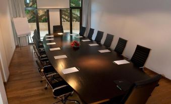a large conference room with a long table and several chairs arranged for a meeting at Hotel Plaza Central Canning