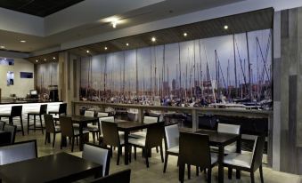 a restaurant with a large mural of boats on the wall , creating a nautical atmosphere at Costa Bahia Hotel, Convention Center and Casino