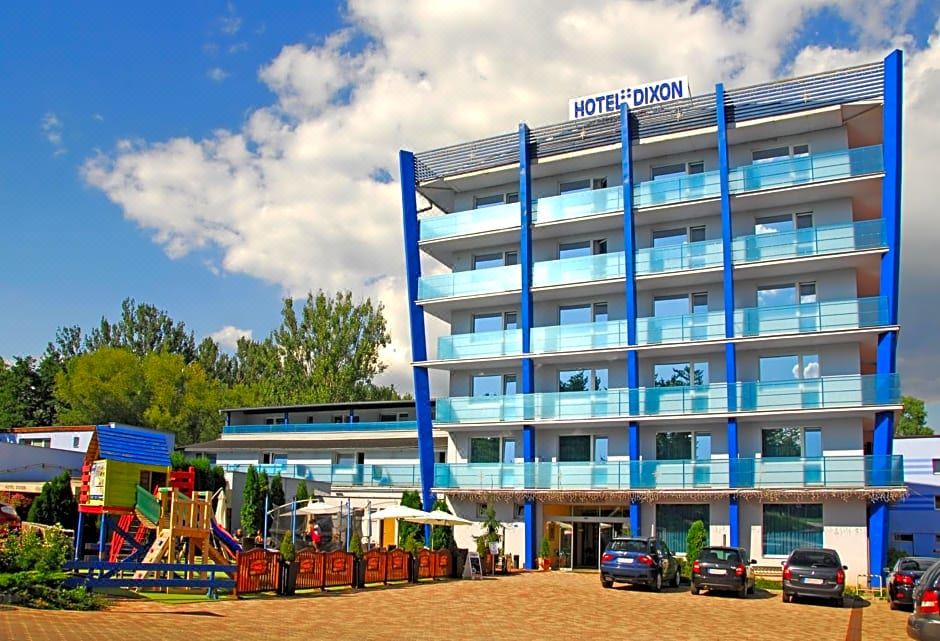 "a blue hotel building with a sign that says "" hotel dizon "" on it , surrounded by other buildings and trees" at Hotel Dixon