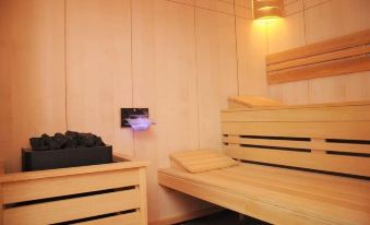 a modern wooden cabin with two beds , one of which has a black jacket and phone , and a small table with a lamp at Alfa Hotel