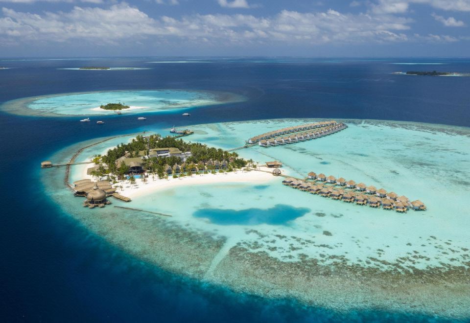 aerial view of a tropical island with a beach , overwater bungalows , and clear blue waters at Outrigger Maldives Maafushivaru Resort