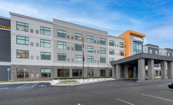"a modern hotel building with the name "" holiday inn express "" on its facade , surrounded by trees and cars parked in the parking lot" at Cambria Hotel Detroit-Shelby Township