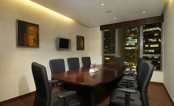 The conference room features a spacious table and chairs, while adjacent to it is an office space equipped with a desk and computer for business needs at Lan Kwai Fong Hotel @ Kau U Fong