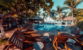 a resort with a large pool surrounded by lounge chairs and palm trees , providing a relaxing atmosphere for guests at Selina Jaco