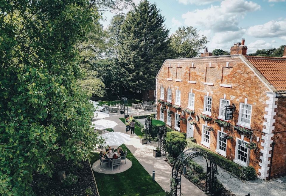an aerial view of a brick building with multiple windows and a courtyard , surrounded by trees at The Knaresborough Inn - the Inn Collection Group