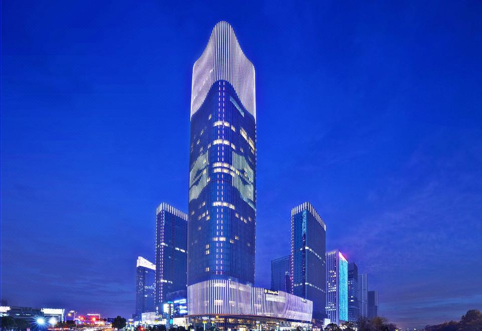 A city at night with buildings illuminated in blue and white colors at Shangri-La Hotel, Yiwu