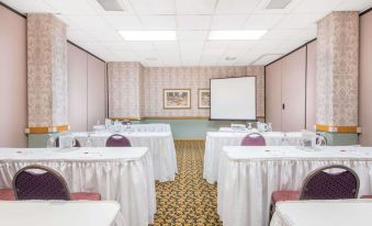 a conference room set up for a meeting with tables and chairs arranged in rows at Ramada by Wyndham Cumberland Downtown