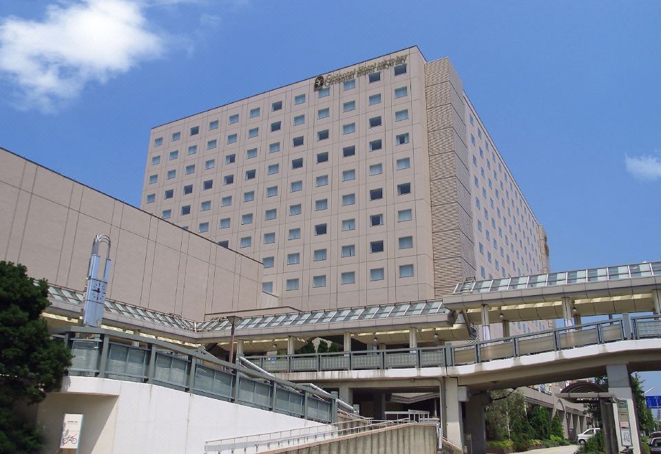 a large , modern building with a white exterior and many windows , situated in a city setting at Oriental Hotel Tokyo Bay
