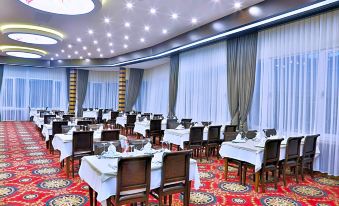 a large dining room with tables and chairs arranged for a group of people to enjoy a meal together at New Marathon Hotel