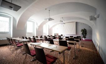 a large conference room with rows of tables and chairs arranged for a meeting or event at Hotel Weitzer Graz